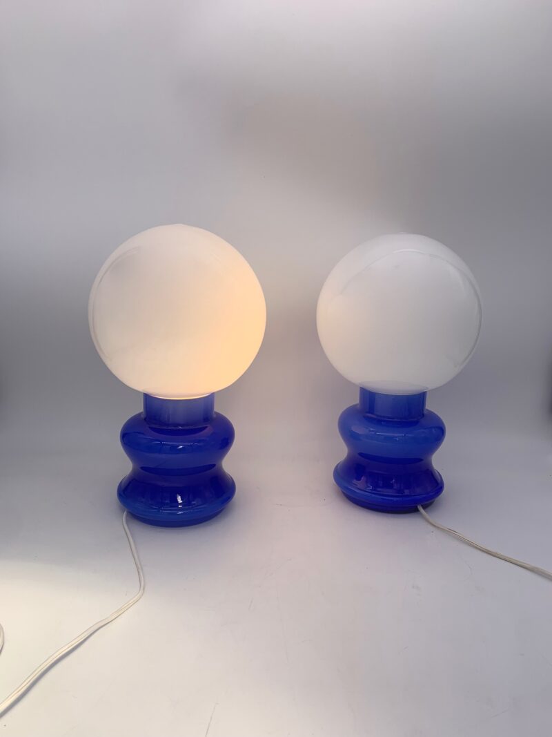 Base in vetro blu con palla lattimo; (coppia) h 27 cm, larg. 15 cm.
